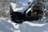 Experience the ultimate winter wonderland with this charming cabin nestled in a snow-covered forest.