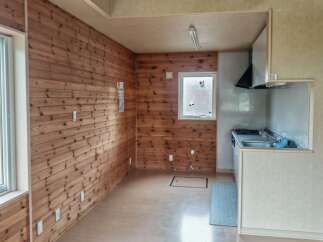 Experience rustic charm in this cozy room featuring warm, wood-paneled walls and a bright, airy atmosphere.