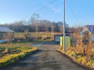 Discover this charming property featuring a cozy home with a wood-paneled exterior and a welcoming asphalt driveway.