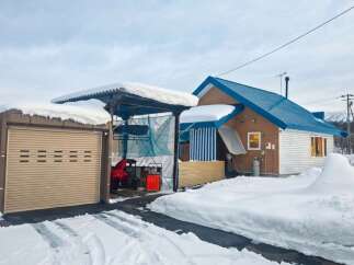 Embrace the winter wonderland with this charming property, featuring a spacious garage and a covered carport perfect for storing snow equipment.