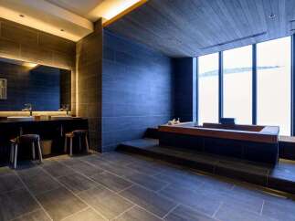 Experience ultimate relaxation in this luxurious bathroom featuring a deep soaking tub with a stunning view.