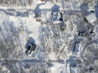 Experience the serene beauty of a winter wonderland with this stunning aerial view of a snow-covered property.
