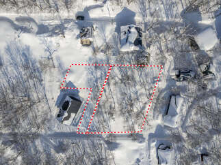 Experience the serene beauty of a winter wonderland with this stunning aerial view of a snow-covered property.