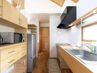 Discover this charming kitchen featuring light wood cabinetry and a sleek stainless steel refrigerator.