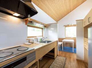 This charming kitchen features a sleek induction cooktop and a deep stainless steel sink, perfect for meal preparation.
