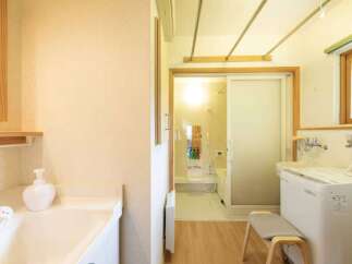 This bright and airy bathroom features a convenient washing machine and a separate shower area, perfect for modern living.