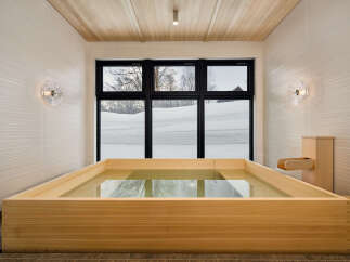 Experience ultimate relaxation in this luxurious bathroom featuring a spacious wooden soaking tub.