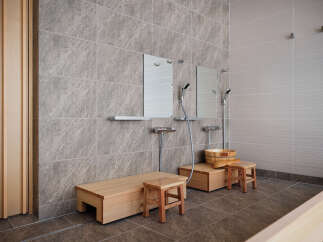 Experience ultimate relaxation in this spa-like bathroom featuring a traditional wooden sauna bench and a separate wooden stool for comfortable seating.
