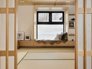 Experience serene winter views from this cozy window seat, complete with plush faux fur throws and decorative pillows.