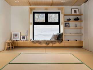 Experience serene winter views from this cozy window seat, complete with plush faux fur throws and decorative pillows.