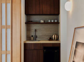 Discover this elegant wet bar featuring rich walnut cabinetry and a sleek stone backsplash.