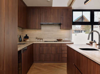 Experience modern luxury in this stunning kitchen featuring rich walnut cabinetry and sleek countertops.