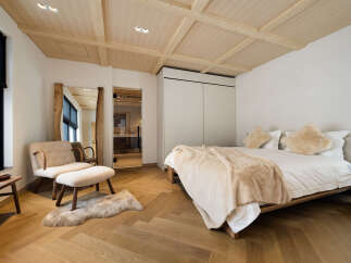 Experience luxury and comfort in this beautifully appointed bedroom, featuring a plush king-sized bed adorned with soft, neutral-toned linens and cozy throws.