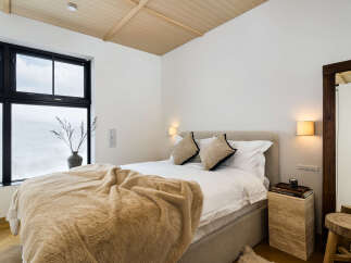 Experience ultimate comfort in this serene bedroom, featuring a plush bed adorned with a luxurious faux fur throw.
