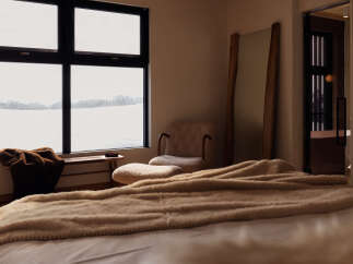 Experience serene winter mornings with expansive views from this bedroom's large windows.