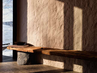 Experience rustic charm and natural beauty in this unique entryway, featuring a live-edge wooden bench resting on a striking stone base.