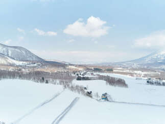 Experience the serene beauty of a winter wonderland with this stunning aerial view of a snow-covered landscape.