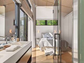 Experience modern luxury in this stunning bedroom featuring a sleek vanity and a comfortable bed.