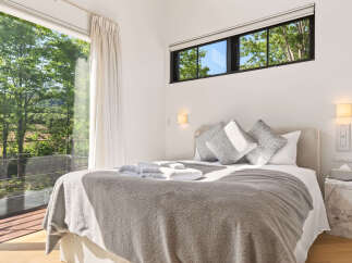 Experience serene living in this beautifully appointed bedroom, featuring a plush king-sized bed and luxurious grey bedding.