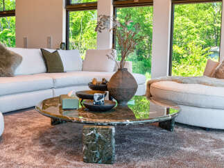 Experience luxurious living in this stunning modern living room, featuring a spacious sectional sofa and a unique marble coffee table.