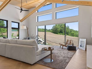 Experience modern living in this stunning home featuring a spacious open-concept living area with soaring vaulted ceilings and exposed wooden beams.