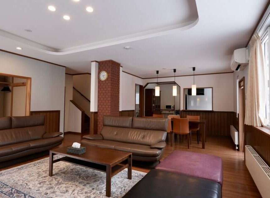 Experience comfort and style in this spacious living area, featuring plush leather sofas perfect for relaxation.