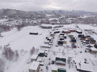 Discover this charming winter village nestled amidst snow-covered mountains.