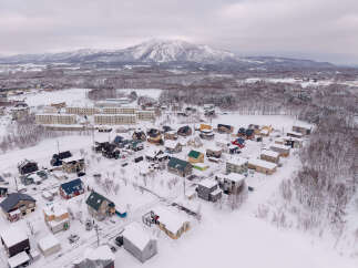 Discover this charming winter wonderland, featuring a picturesque village nestled against a majestic snow-capped mountain.