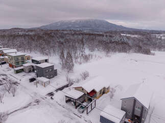 Experience serene winter living in this charming property nestled amidst snow-covered landscapes and a majestic mountain backdrop.