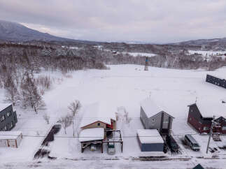 Experience the serene beauty of a winter wonderland with this property nestled amidst snow-covered landscapes and majestic mountains.