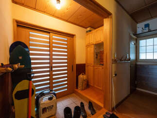 Discover a welcoming entryway featuring a sliding door with horizontal blinds, perfect for natural light diffusion.
