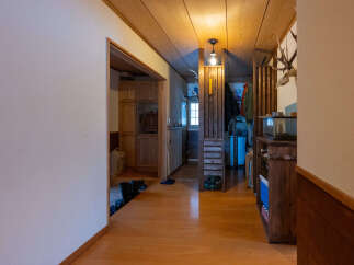 Step into this charming entryway featuring warm wooden floors and ceiling, creating a cozy and inviting atmosphere.