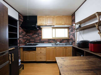 Discover this charming kitchen featuring rustic brick-style backsplash and warm wooden cabinetry.