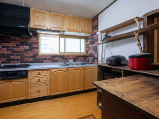 This charming kitchen features a rustic brick backsplash and warm wooden cabinetry, creating a cozy and inviting atmosphere.