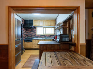 Step into this charming kitchen, featuring warm wooden cabinetry and a rustic brick backsplash.