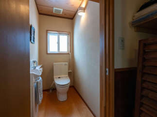 Discover this charming bathroom featuring a modern toilet and a sleek sink with a convenient towel rack.