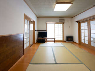 Experience traditional Japanese living in this spacious room featuring tatami mat flooring and elegant shoji screen doors.