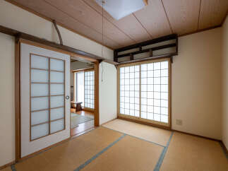 Experience traditional Japanese living with this serene room featuring tatami mat flooring and shoji screens.