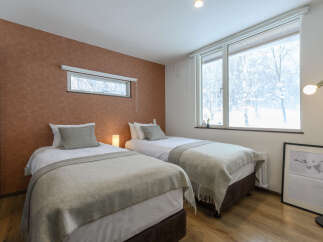 Experience cozy comfort in this charming bedroom featuring two twin beds, perfect for guests or a family.