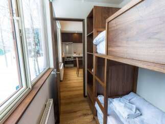 Experience cozy living in this compact space featuring a functional kitchenette and comfortable bunk beds.
