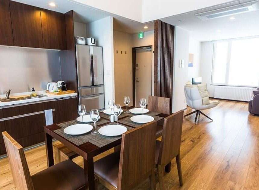 This modern apartment features a fully equipped kitchen with dark wood cabinetry and stainless steel appliances, perfect for preparing meals.
