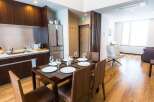 This modern apartment features a fully equipped kitchen with dark wood cabinetry and stainless steel appliances, perfect for preparing meals.