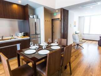 This modern apartment features a fully equipped kitchen with dark wood cabinetry and stainless steel appliances, perfect for preparing meals.
