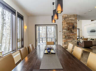 Experience elegant dining in this spacious room, featuring a large wooden table surrounded by comfortable leather chairs.