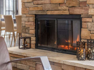 Cozy up by the inviting fireplace, a stunning focal point crafted from natural stone.