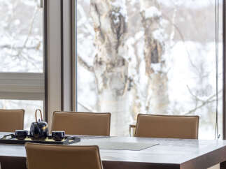 Enjoy a serene dining experience with this elegant table setting, featuring a dark teapot and cups on a tray.