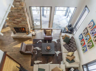 Experience luxury living in this stunning multi-level home featuring a grand stone fireplace and expansive windows offering breathtaking views.