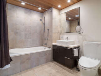 This modern bathroom features a deep soaking tub with a shower, perfect for relaxation.