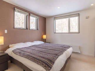 Experience comfort and style in this inviting bedroom, featuring a plush king-sized bed adorned with a decorative throw.