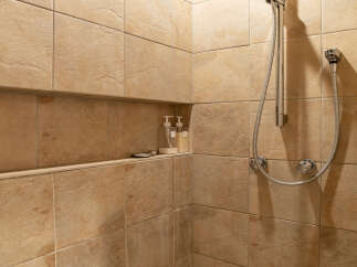 Experience a spa-like retreat in this beautifully tiled shower featuring a convenient built-in niche for toiletries.